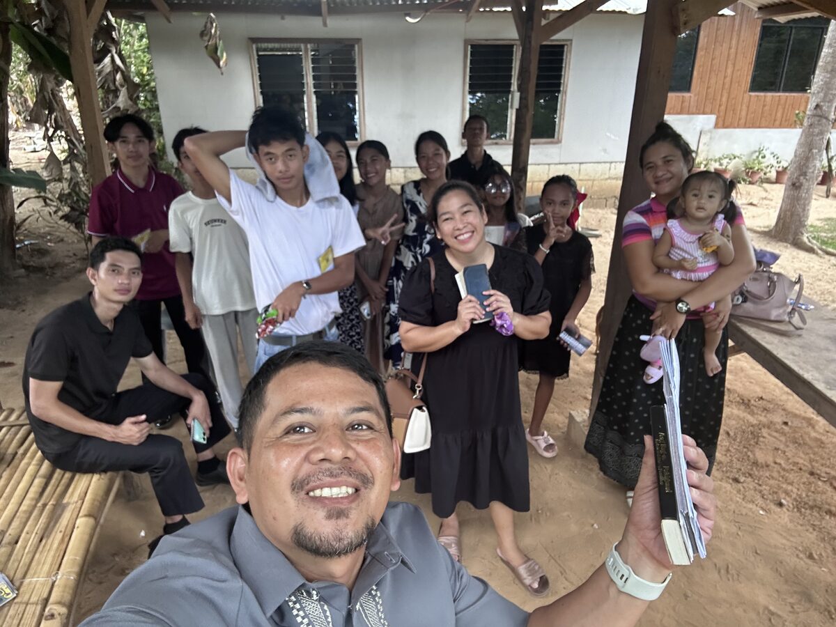 Pastor Melfer and church members gathered with their Bibles outside a home during visitation
